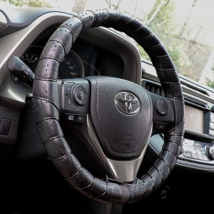 Classic lace on steering wheel cover installed on car interior, showing breathable leather texture and DIY hand-sewn finish.