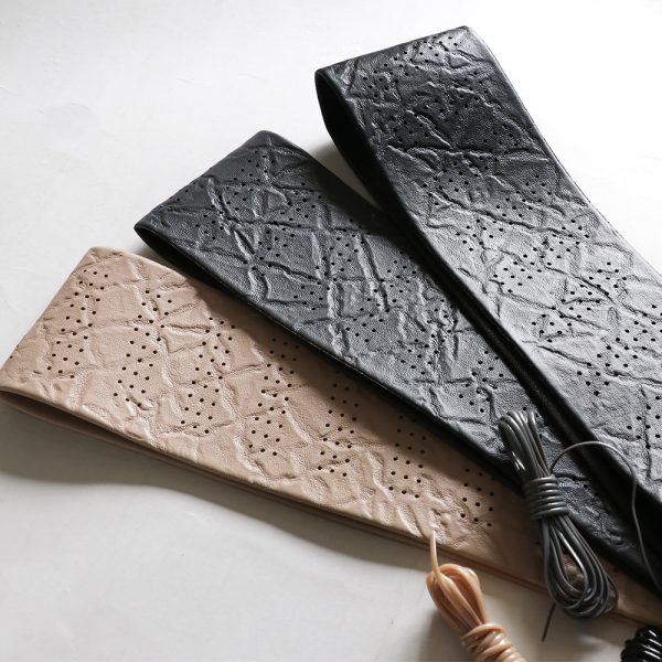 Classic lace on steering wheel cover leather materials in black and beige, showing perforated breathable texture and sewing cords.