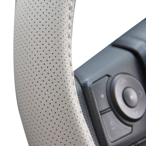 Close up perforated leather steering wheel cover beige