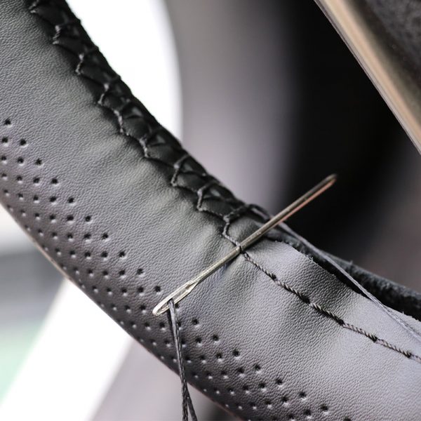 Close-up of stitch steering wheel cover on genuine leather