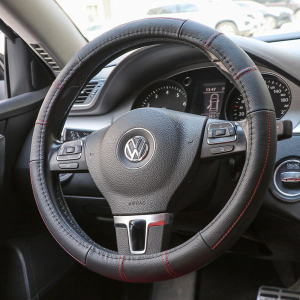 Close-up of red thread leather steering wheel cover on car